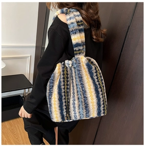 Detail of colorful striped faux fur tote bag featuring drawstring and wide strap