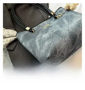 Close-up of gray tote bag with black round leather handles and white plush charm detail