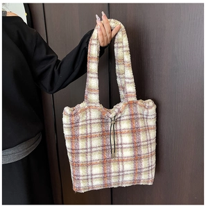 Detail of plush plaid tote bag featuring checkered fleece texture and drawstring closure