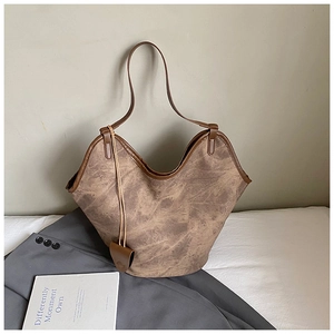 Detail of vintage brown tote bag with leather straps and side pouch on office suit