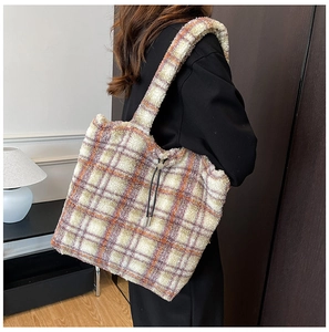 Detail of soft plush tote bag featuring retro orange and purple plaid pattern with drawstring