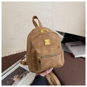 Detail view of mini tan matte leather backpack with golden hardware and front zip pocket