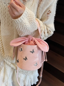 Pink bucket bag with silver butterfly charms and rabbit ear drawstring closure
