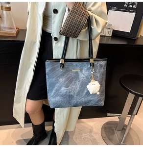 Blue-grey marble print tote bag detail with gold bar decor and plush lamb keychain