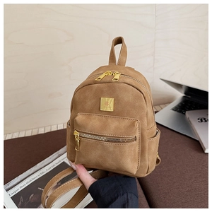 Detailed macro view of brown frosted leather texture and golden metal zipper on backpack