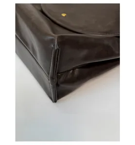 Détail des coins renforcés et des coutures fines sur le sac cabas en cuir marron foncé
