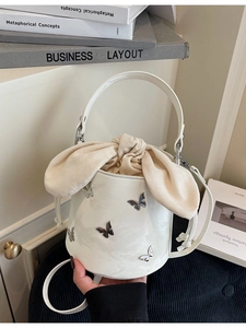 White mini bucket bag with silver metal butterfly charms and drawstring inner pouch