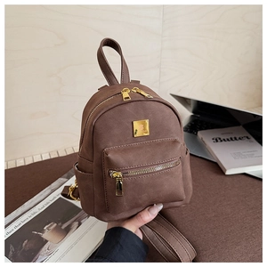 Detailed macro view of brown faux leather mini backpack with gold hardware and logo