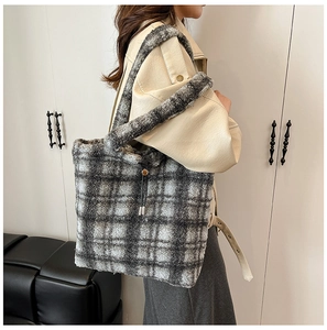 Side view of large fuzzy grey and white plaid tote bag worn by a model in minimalist room