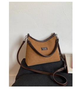 Detail of vintage brown suede crossbody bag with leather trim and gold-tone zipper