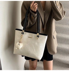 Minimalist beige tote bag with black trim and a cute plush lamb charm for women