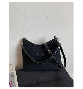 Close-up of black matte shoulder bag with Lazy Breeze brand label and silver metal buckle