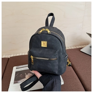 Detail shot of mini black faux leather backpack with gold zippers and hardware