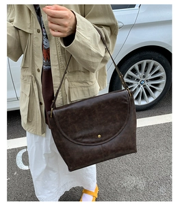 Détail d'un sac cabas marron foncé en similicuir avec boucle métallique à bille dorée