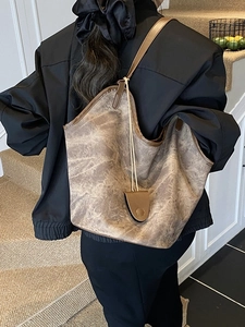 Retro brown leather tote bag with marble texture shown on a model in a home setting