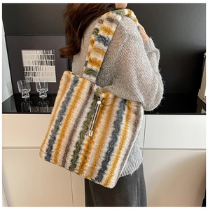 Close-up of fuzzy striped tote bag in yellow, blue and grey with soft plush texture