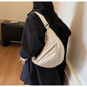 Dettaglio borsa a mezzaluna beige con texture in nylon stropicciato e tira lampo tessuto
