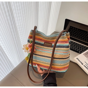 Detailansicht der mehrfarbig gestreiften gewebten Beuteltasche mit Blumenanhänger