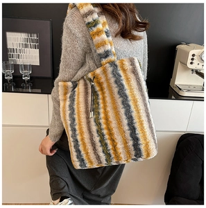 Detail of striped faux fur tote bag in yellow, gray, and white on a model's shoulder