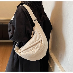 Dettaglio di una borsa a tracolla beige in nylon a mezzaluna con tiralampo intrecciato