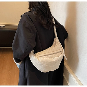Dettaglio della borsa a mezzaluna beige con tessuto a pieghe e tracolla regolabile
