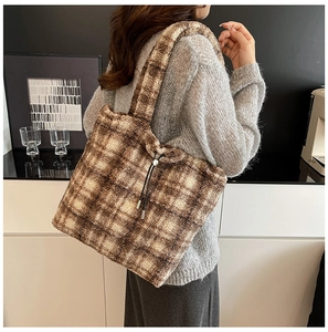 Detail of checkered sherpa tote bag in coffee brown with black drawstring accents