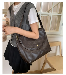 Détail du grand sac cabas vintage marron foncé avec bouton doré et bandoulière large