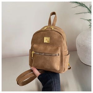Close-up of a brown frosted leather mini backpack with golden metal zippers and logo