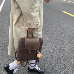 Dettaglio dello zaino vintage marrone con patta in pelle liscia e fibbia in metallo
