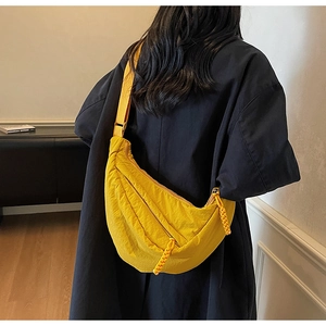 Dettaglio della borsa a mezzaluna in nylon giallo con doppia zip e tiretti in corda