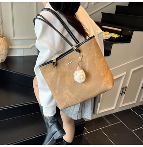 Detail of tan vintage tote bag featuring matte texture and plush doll charm decoration