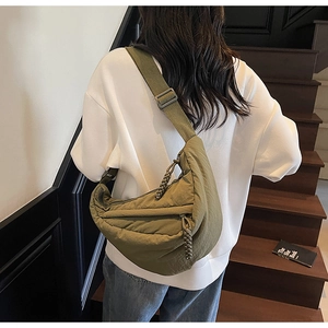 Dettaglio borsa a mezzaluna in nylon verde militare con tiranti intrecciati e tracolla