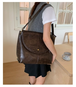 Gros plan d'un grand sac fourre-tout vintage marron avec boucle dorée sur table
