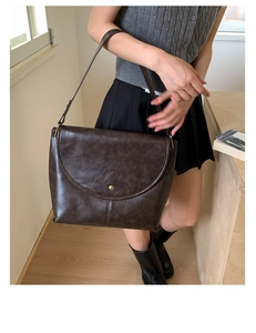 Détail du sac cabas marron foncé avec boucle dorée porté à l'épaule pour femme