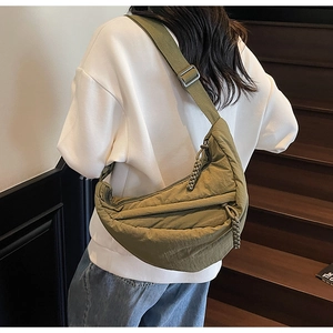Dettaglio borsa a mezzaluna in nylon verde oliva con tirante intrecciato e tracolla