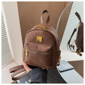 Detail shot of brown frosted mini backpack with golden zippers and metal logo plate