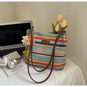 Detail der bunt gestreiften gewebten Tragetasche mit Lederriemen und Strickblume