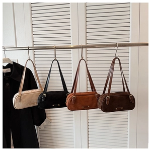 Detail view of four-color suede baguette bags with gold hardware and twin straps