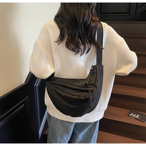 Dettaglio della borsa a mezzaluna in nylon nero con cerniera intrecciata e tessuto opaco