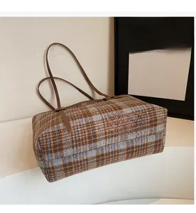 Détail du sac cabas tissé à carreaux marron et bleu clair avec anses en cuir