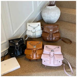 Detailed view of mini chain backpacks in five trendy colors on a carpeted staircase