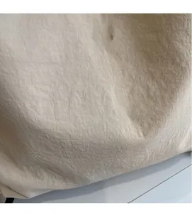 Dettaglio del tessuto beige dello zaino con texture a pieghe e fibbia in metallo M FASHION