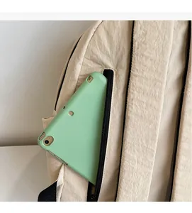 Dettaglio della tasca laterale con cerniera di uno zaino in nylon crema con tablet