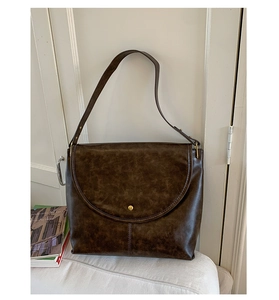 Détail du grand sac cabas vintage marron foncé avec bouton doré et texture cuir premium