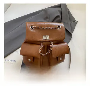 Detail of vintage brown backpack showing lychee texture leather and silver chain