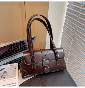 Detail of dark brown vintage shoulder bag with large silver buckle and rivet studs