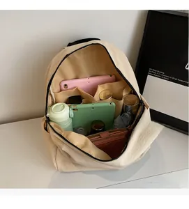 Vista interna dello zaino in tela beige con scomparti organizzati per tablet e borraccia