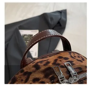Détails du sac en velours léopard avec poignée en cuir marron et double zip argenté