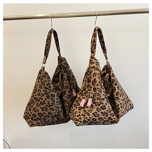 Detail of leopard print pleated tote bag featuring unique fold design and pink leather buckle