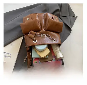 Top view of spacious brown leather backpack interior holding a tablet and cosmetics
